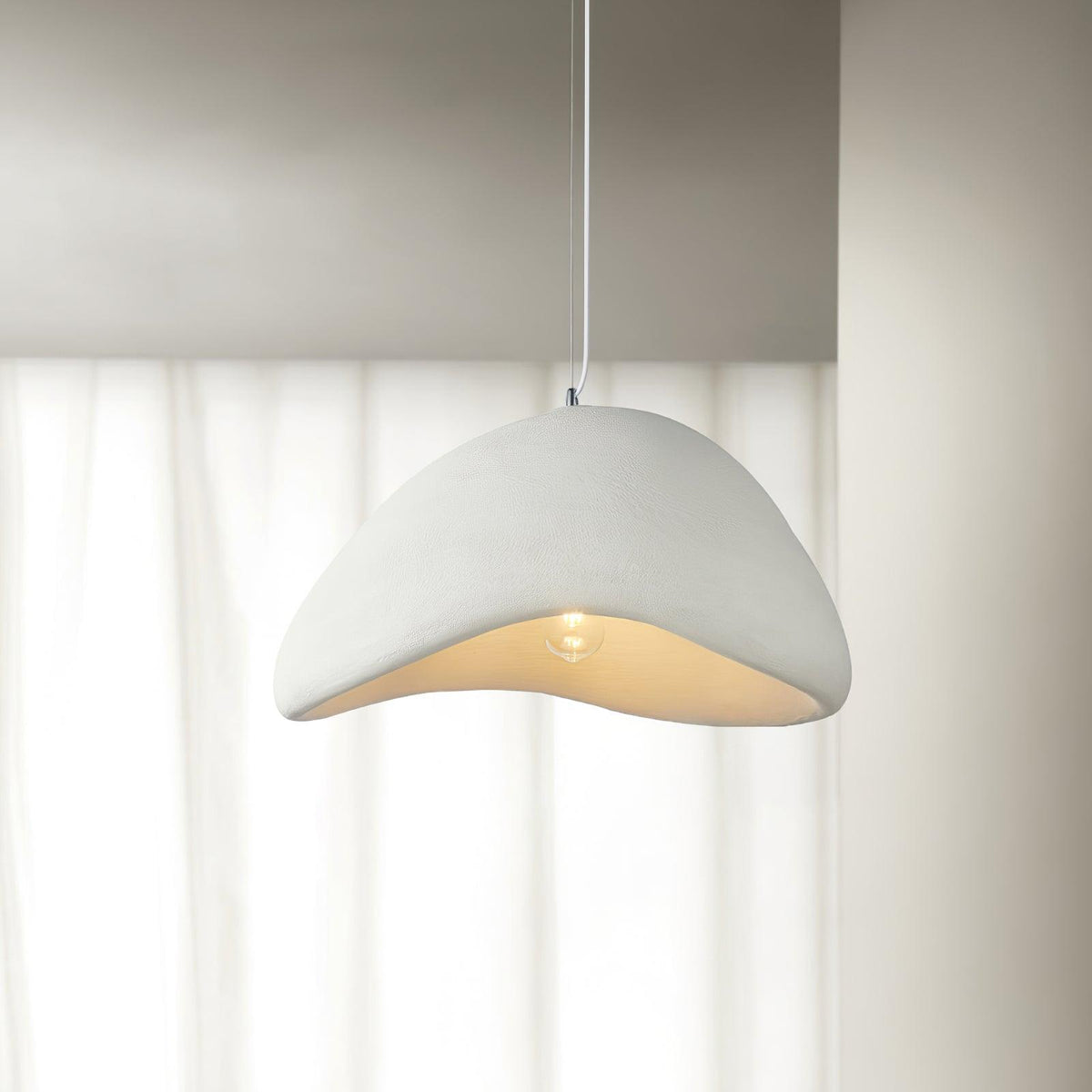 Lampada a sospensione con paralume curvo organico, texture morbida e stile artistico moderno