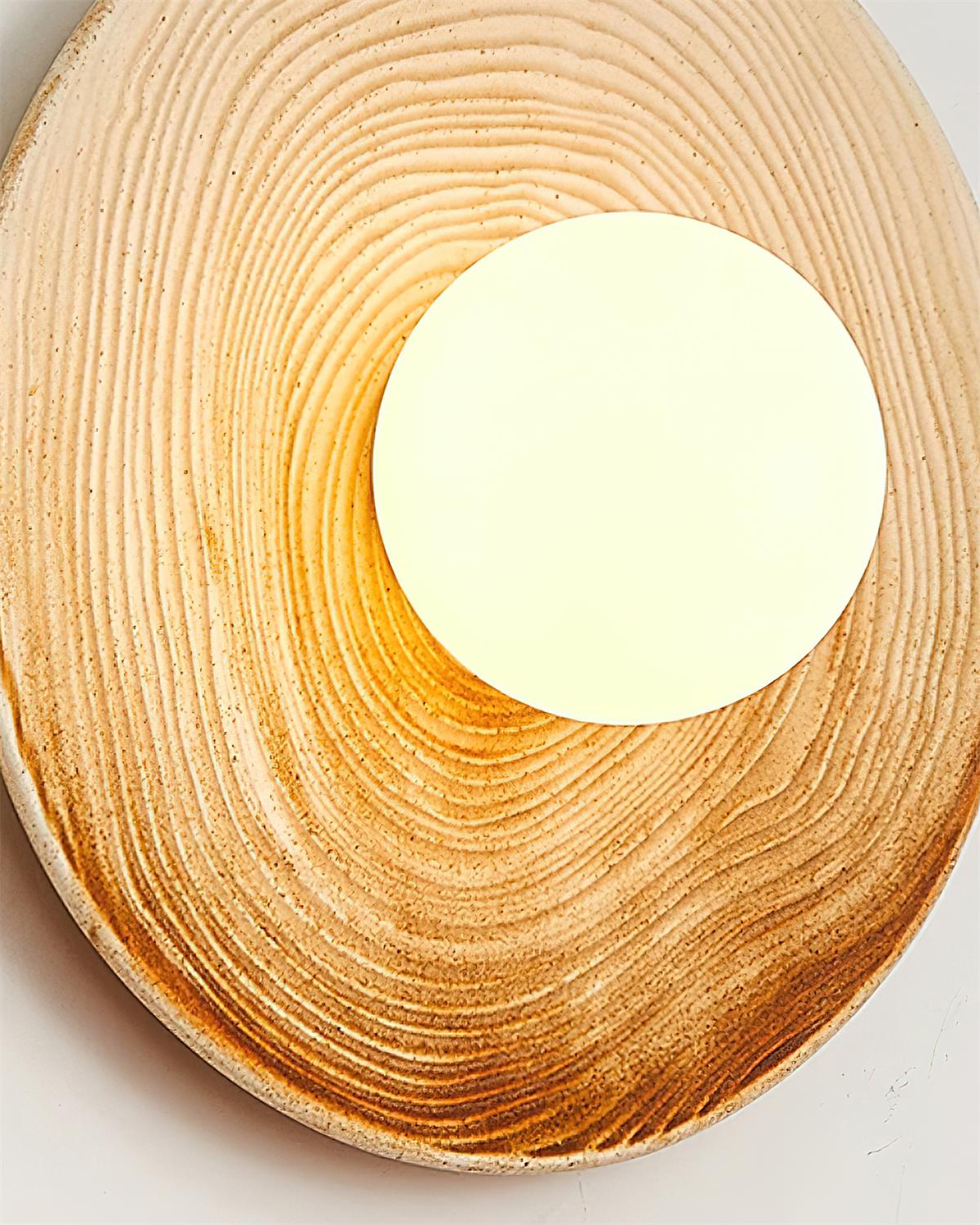 Lampada da parete in ceramica testurizzata con disco e dettagli in legno per ingresso moderno
