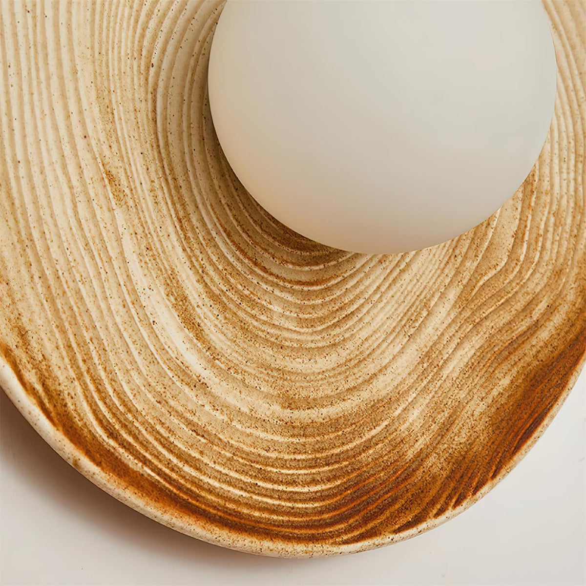 Lampada da parete in ceramica testurizzata con disco e dettagli in legno per ingresso moderno